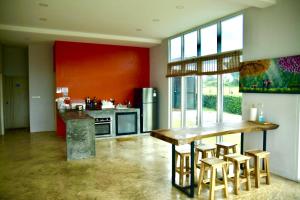 a kitchen with a wooden table and some stools at Aly’s house in Ban Phlu Thong