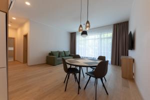 a dining room and living room with a table and chairs at Oasis Apartments in Jūrmala