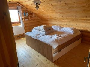a bedroom with a bed in a wooden cabin at TRINITY Log Cabin Wellness resort in Štrba