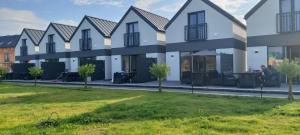 a row of houses with a lawn in front at Domki Puszek in Łeba +45 photos