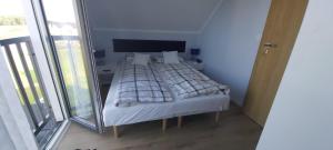 a bed in a room with a large window at Domki Puszek in Łeba