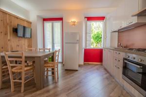 a kitchen with a table and a white refrigerator at Il tulipano della Valle Soana in Ronco Canavese