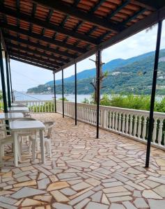 a patio with tables and chairs and a view of the water at Peyko Rooms in Keri +17 photos