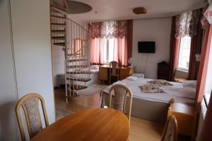 a room with a bed and a table and a staircase at Hotelli Iisalmen Seurahuone in Iisalmi