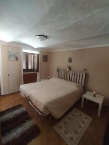 1 dormitorio con 1 cama grande y 1 mesa en La Casa di Vitto en Boves