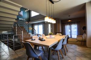 a dining room with a table and chairs and a staircase at Aigli Luxurious Villa in Káto Pitsá +36 photos
