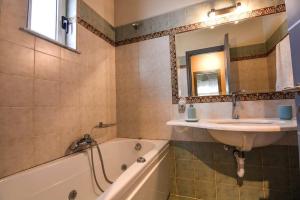 a bathroom with a sink and a bath tub at Aigli Luxurious Villa in Káto Pitsá