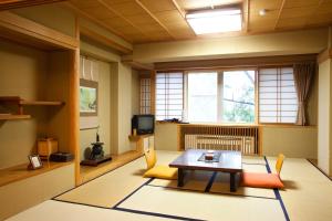 山之內的住宿－滋賀縣太陽谷志賀高原酒店，客厅配有桌椅和电视。