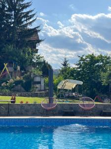 einen Pool mit zwei Stühlen und einer Schaukel in der Unterkunft Exclusive Apartments Bistrik in Sarajevo