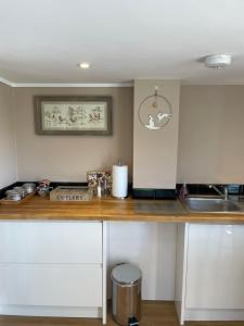 a kitchen counter with white cabinets and a sink at Hideaway in Bradford on Avon