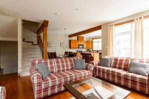 een woonkamer met 2 banken en een tafel bij Serenity Peaks Lodge by InstantSuites-LaBete Golf in Mont-Tremblant