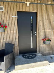 a black door of a house with two pots of flowers at Vadlåsveien 4 in Egersund