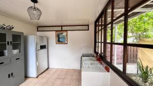 een keuken met een koelkast en een aantal ramen bij Matatia Lodge in Punaauia