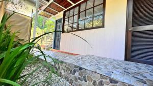 a front door of a house with a stone walkway at Matatia Lodge in Punaauia