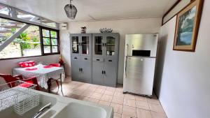 a kitchen with a stainless steel refrigerator and a table at Matatia Lodge in Punaauia