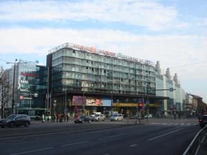 un gran edificio de cristal en una calle de la ciudad con coches en Estinn Apartment, en Tallin