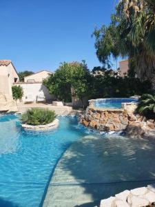 einen Pool mit blauem Wasser im Hof in der Unterkunft Maisonnette piscine en été clim in 