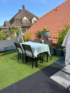 a table and chairs on a yard with grass at Appartement SEPHORA in La Neuveville