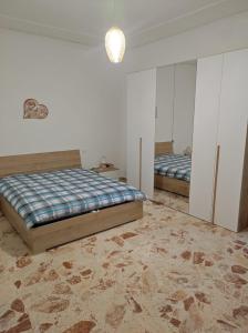 a bedroom with two beds and a rug at Casa vacanze ferro in Trapani