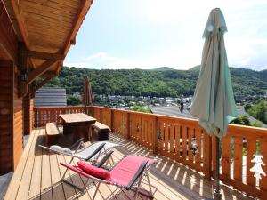 a deck with a table and chairs and an umbrella at Le Mont-Dore: Splendide Chalet 5 Chambres avec Terrasse, Garage Double, et WiFi - FR-1-608-188 in Le Mont-Dore