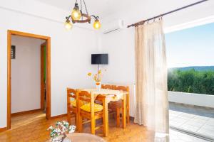 a dining room with a table and a large window at panorama view apartment in Sitia