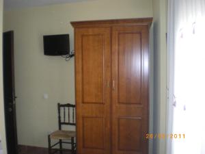 a wooden door in a room with a chair and a television at Casa de la abuela María in Libros