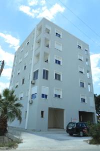 een wit gebouw met een auto ervoor geparkeerd bij E&G apartaments in Golem