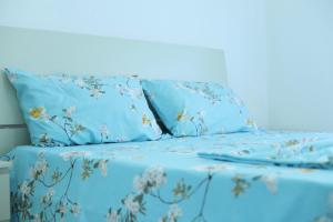 een bed met blauwe lakens en bloemen erop bij E&G apartaments in Golem