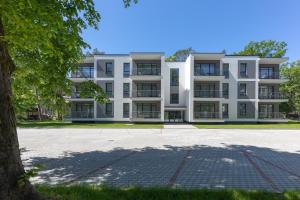 an apartment building with a tree in front of it at Oasis Apartments in Jūrmala