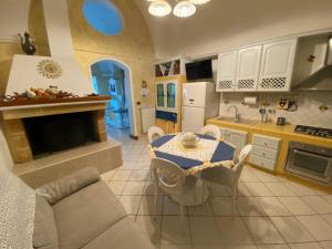 cocina y sala de estar con mesa y sillas en Il Geco, en Salice Salentino