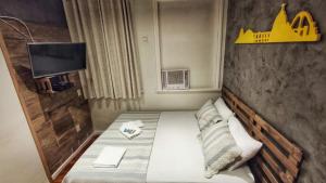 Un pequeño dormitorio con una cama con un cartel en la pared en Rio Deal Guest House, en Río de Janeiro