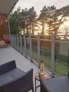 a balcony with a table with wine glasses on it at Apartament BalticHoff w Let's Sea Baltic Park Gąski in Gąski