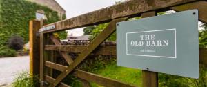 an old barn sign on a wooden fence at The Old Barn in Buxton