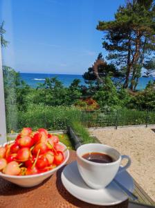 a bowl of tomatoes and a cup of coffee on a table at Apartament BalticHoff w Let's Sea Baltic Park Gąski in Gąski