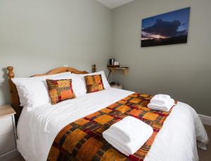 a bedroom with a large bed with towels on it at The Old Barn in Buxton