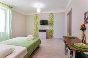 a bedroom with a bed and a table and a television at Апартаменты Central Park в центре Тюмени in Tyumen