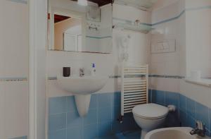 baño azul y blanco con lavabo y aseo en PRIA de MAR en Riomaggiore
