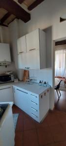 una cucina con armadi bianchi e piano di lavoro di La Tana di Margherita a Perugia