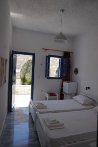 a bedroom with two beds and an open door at Michaela's in Drios
