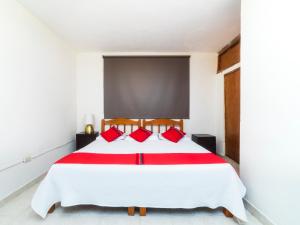 1 dormitorio con 1 cama blanca grande con almohadas rojas en Los Pueblitos de Guanajuato Hotel en Guanajuato