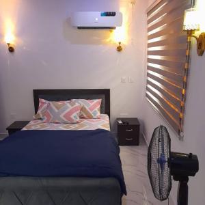 a bedroom with a bed and a fan at Easyinn Shortlet Apartment in Port Harcourt