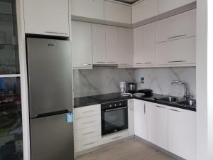 una cucina bianca con lavandino e piano cottura di Lovely 1-Bedroom Apartment at San Pietro Beach Front Resort a Mullini i Danit