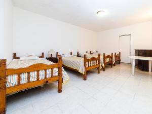 um quarto com uma fila de camas de madeira em Los Pueblitos de Guanajuato Hotel em Guanajuato