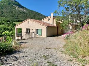 a large house with a mountain in the background at Villa de vacances 6 personnes in Orpierre
