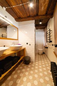 a bathroom with two sinks and a toilet at Fotogrāfa Apartamenti in Kuldīga