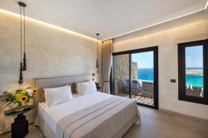 a bedroom with a bed and a view of the ocean at Tropicana Hotel , Suites & Villas Mykonos in Paradise Beach