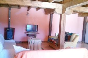uma sala de estar com uma cama e uma televisão em La casa azul del Pantano em La Costana