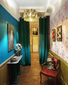 Cette chambre dispose de rideaux verts et d'une chaise rouge. dans l'établissement B&B Château de Fajac la Selve, à Pech-Luna