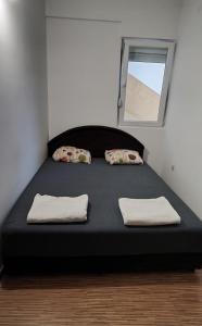 ein Bett mit zwei Kissen und einem Spiegel in einem Zimmer in der Unterkunft Sunrise Djenovici in Ðenovići