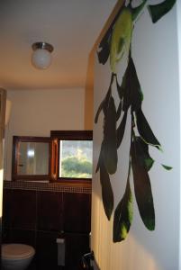 une salle de bains avec une peinture murale représentant une plante. dans l'établissement Case Giannone, à Santa Flavia